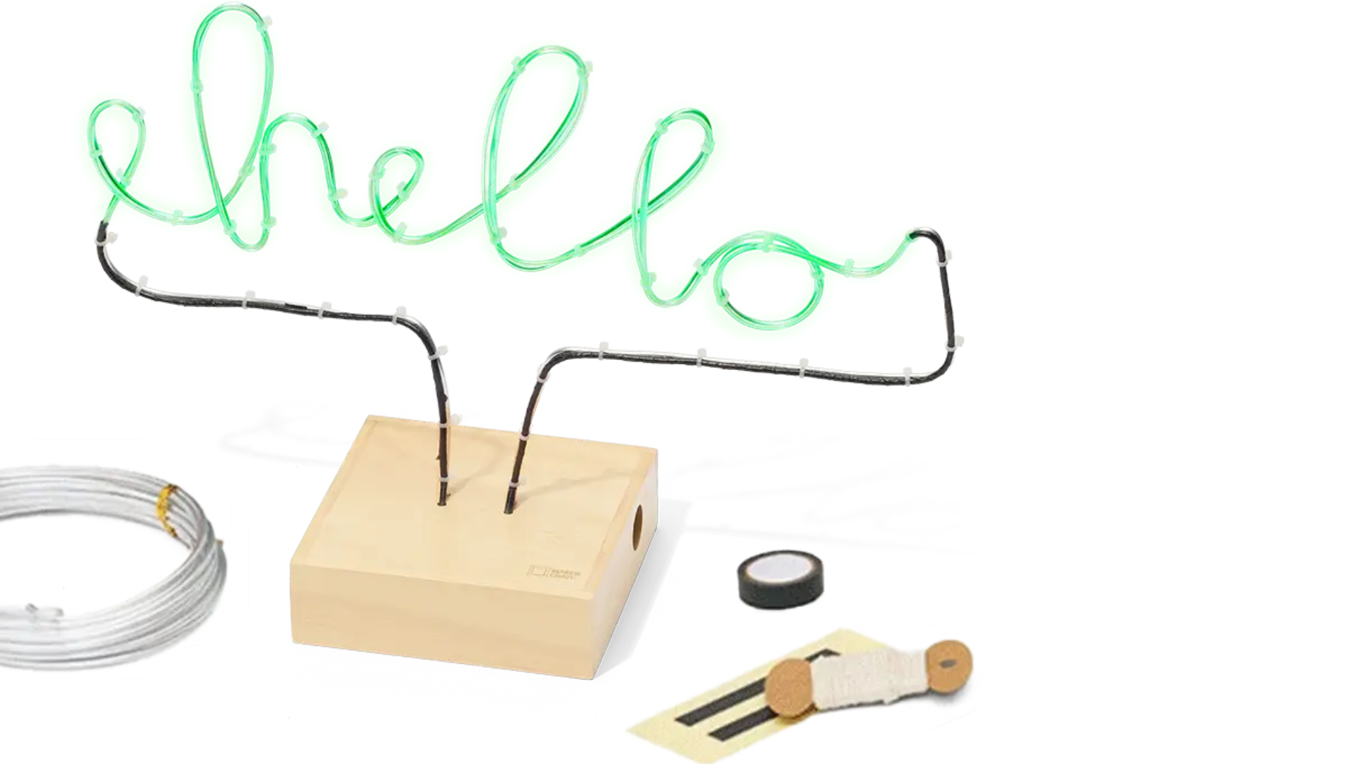 A completed neon wire sculpture that says "hello" surrounding by supplies: wire, electrical tape, and pliers.